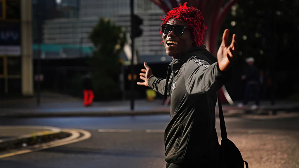 Thaispeáin físeáin gur rug sé greim ar bhuachaill scoile ag a éide agus bhí ceann eile leis ag troid le fear le ‘dwarfism’.