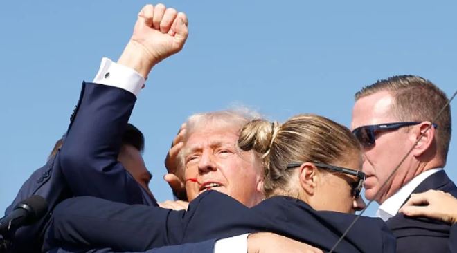 Tógadh Trump as an stáitse ag cur fola óna chluas