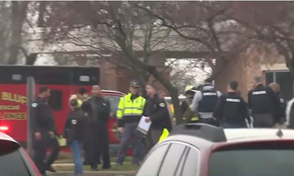 Theith na daltaí is óige ón bhfoirgneamh amach sa bhfuacht gan chótaí, agus iad ag coinneáil lámha a chéile ar mhaithe le sábháilteacht