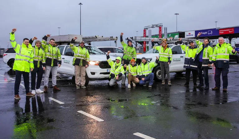 Foireann oibrithe leictreachais ón Ostair tar éis dóibh Calafort Bhaile Átha Cliath a bhaint amach