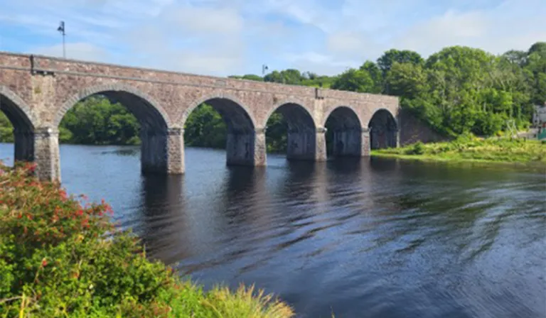 Sean-iarnród áirseach (archway) thar Abhainn na Dairge Duibhe (Black Oak River) ann