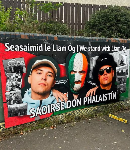 Nochtadh múrphictiúr nua ag tacú le Kneecap in Iarthar Bhéal Feirste roimh a láithriú cúirte