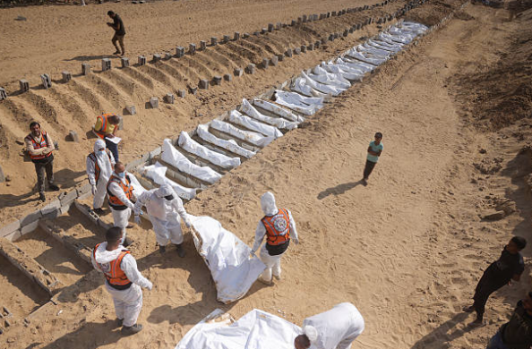 Rinne oibrithe sláinte agus sibhialta adhlacadh mais Palaistíneach ag reilig i Khan Yunis, ar an 10 Samhain 