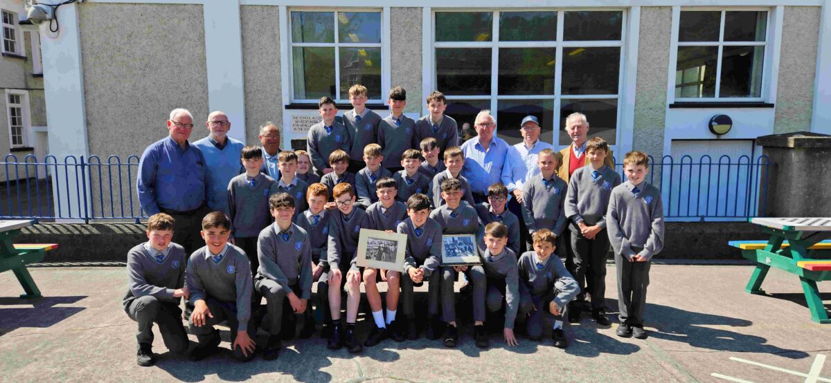 GAA 70s Scoil Mhuire with members from 70s team. Pupils holding photos thats on their school wall since 1974 Neural