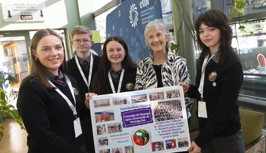 Scoláirí Gaelcholáiste Chiarraí, Trá Lí,  Sarah Ní Fhoghlú, Tadhg Ó hOibeard, Evelyn Ahern, agus Isla Nic Mhuiris ag taispeáint a bpóstaeir don Uachtarán
